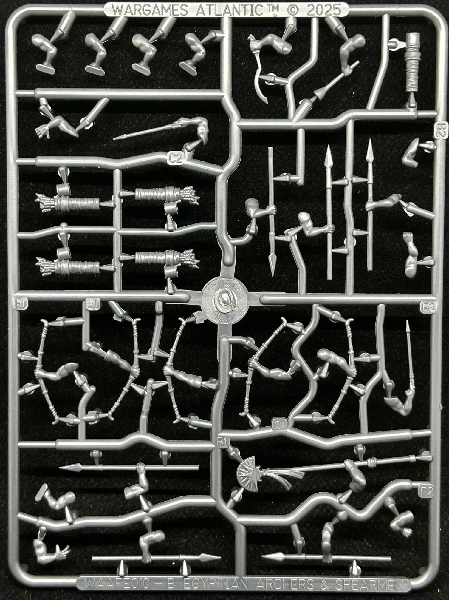 A silver plastic sprue containing various miniature model parts, including weapons, armor, and accessories, on a black background. The top of the sprue features the text 'WARGAME'S ATLANTIC' with a copyright year 2025.